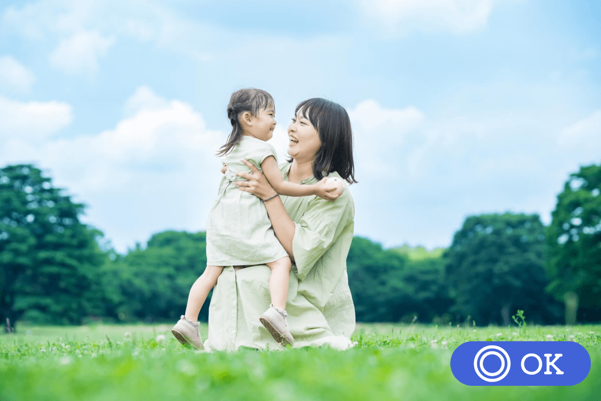 広場で遊ぶ子どもと母親の画像